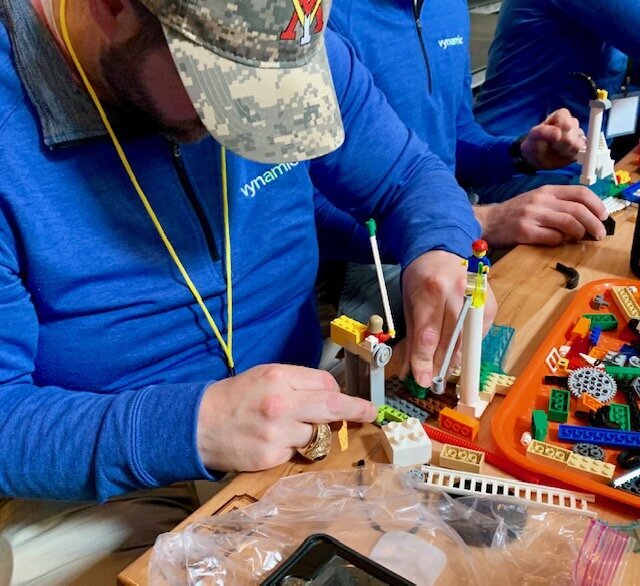 Man at a Lego Serious Play event building with LEGO bricks.
