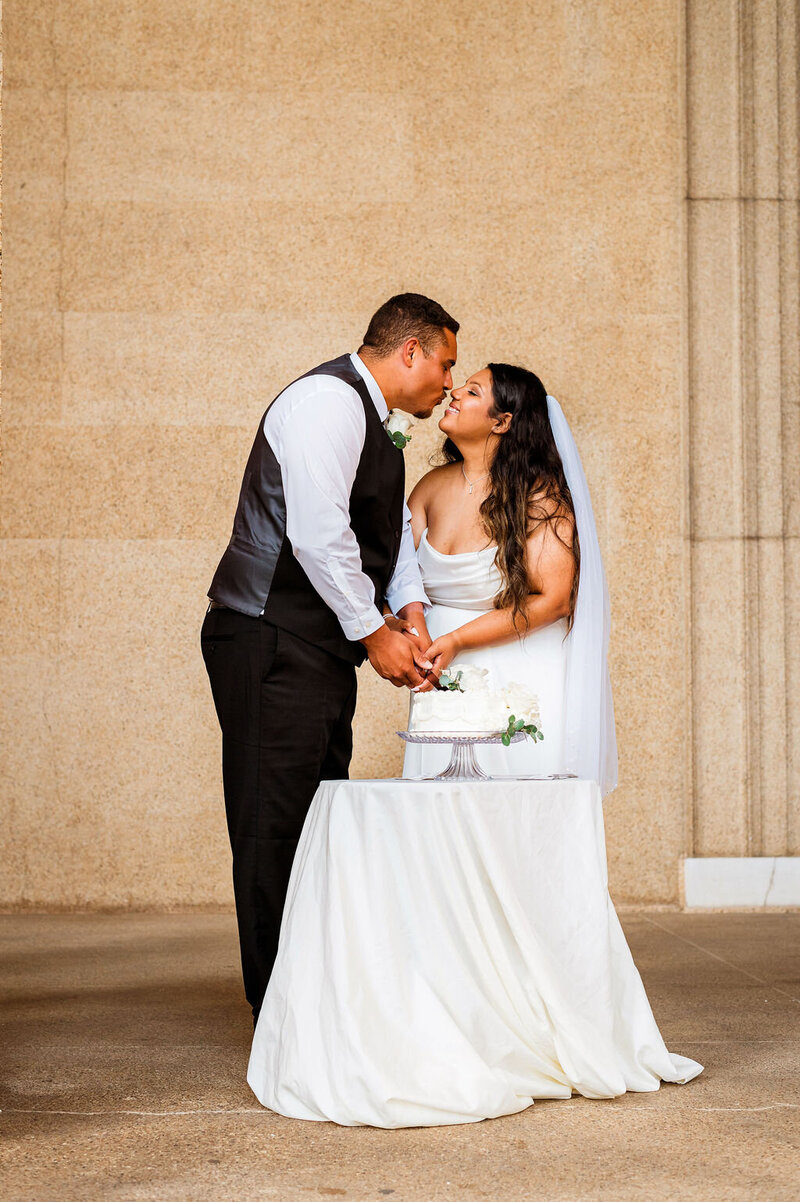 Couple about to kiss before the cut their wedding cake on the steps of the Parthenon in Nashville