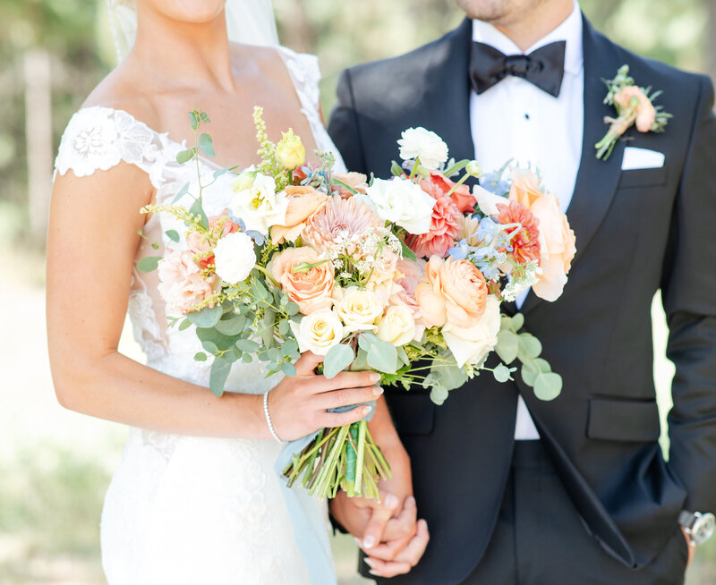 Close up view of Lauren's bridal bouquet. Various colors of peach, white, and green.