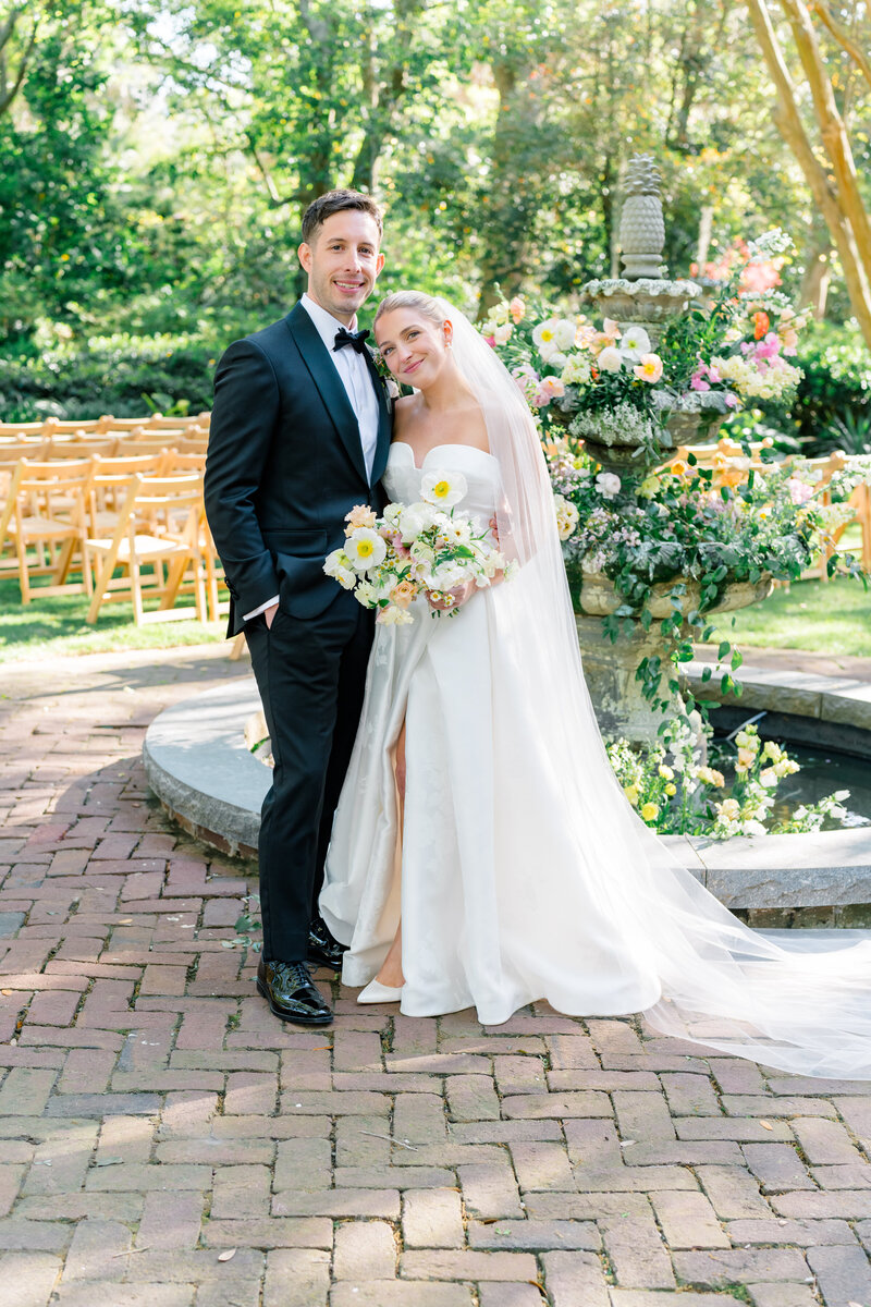 Spring wedding. Bride and groom in front of pineapple fountain at Governor Thomas Bennett House.