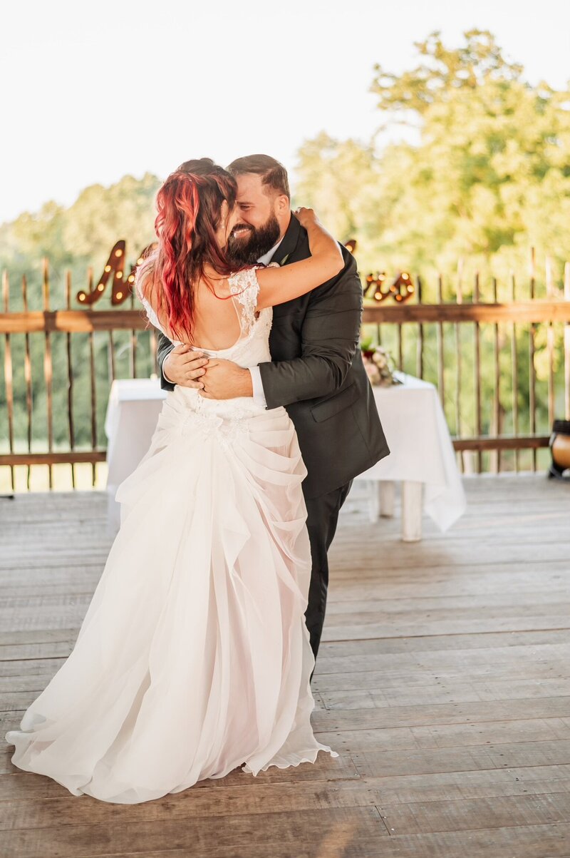 Groom hugging bride while doing their first dance