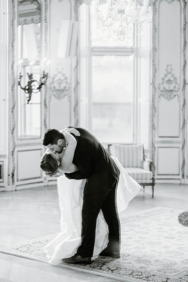 Ochre Court Newport | A couple dances closely in an elegant, light-filled room. The man is dipping the woman, who wears a flowing dress.