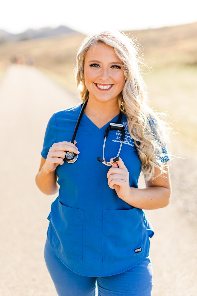 a girl wearing blue scrubs and a stethoscope