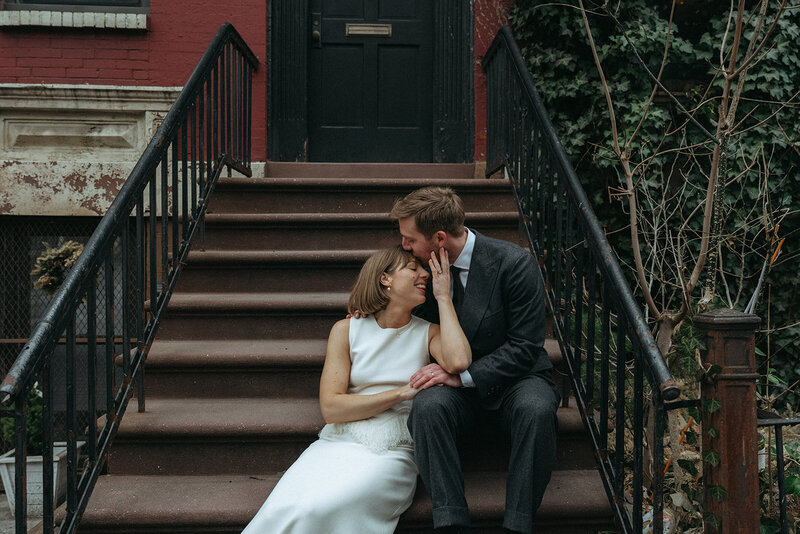 bride and groom sitting on brownstone steps after NY city hall elopement shot by Elsie Goodman Photography | NYC Elopement Packages