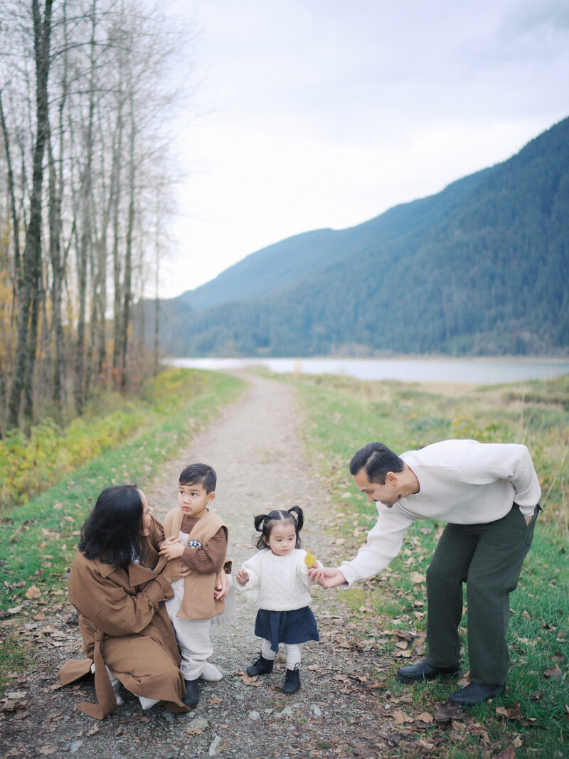 A family  of four hanging out together at Pitt Lake for family photos