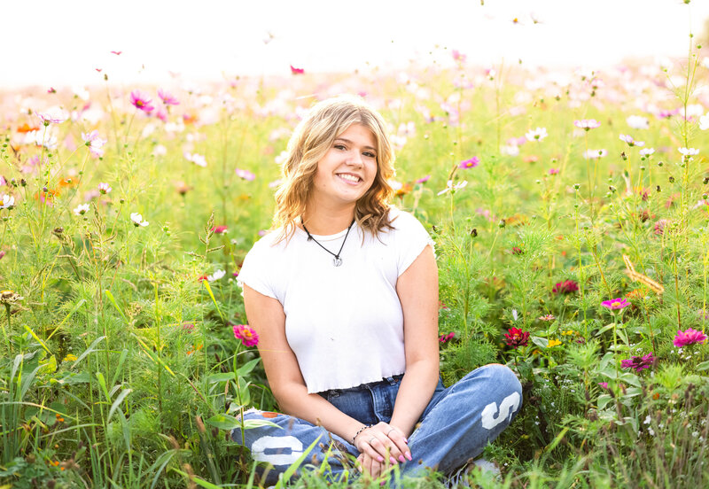 high school senior girl sitting in flower field