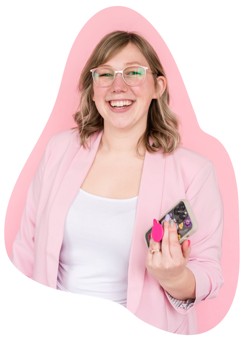 Cutout image of Kat Murphy in a light pink blazer holding an iphone in front of a pink background