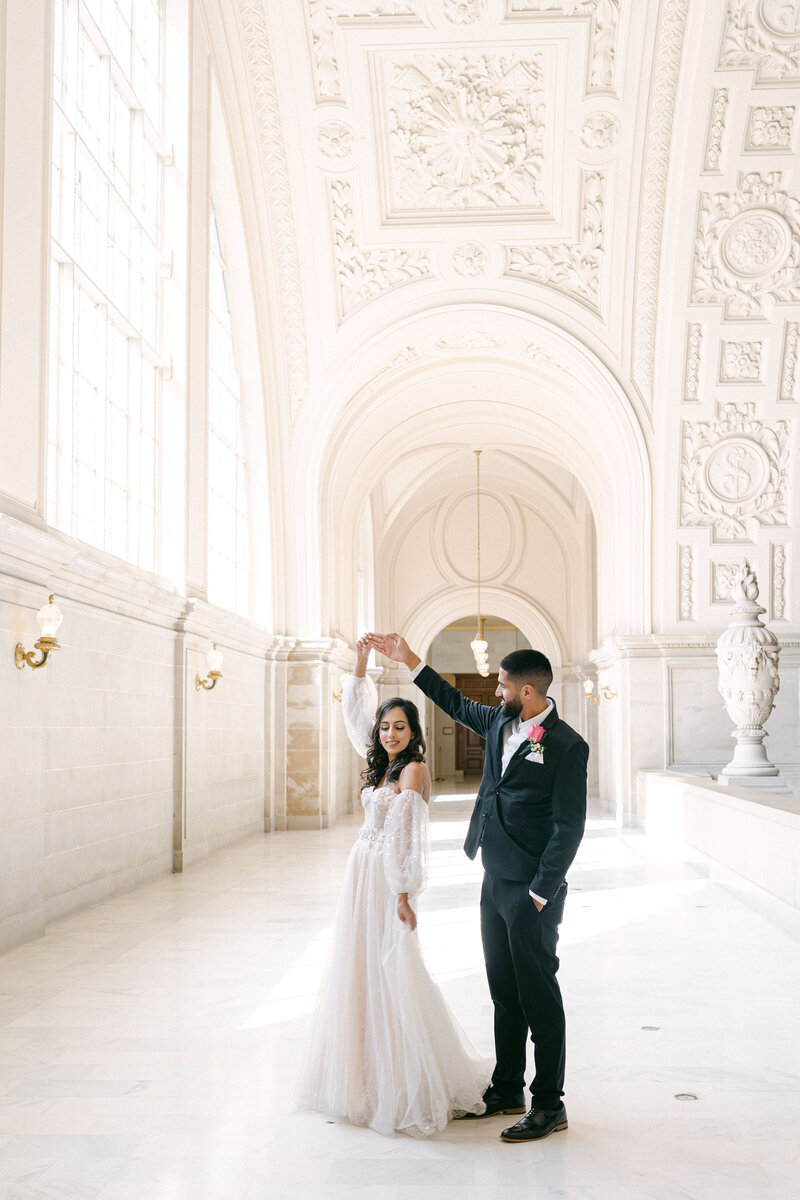 wedding couple twirling in the grand hall of the San Francisco City hall