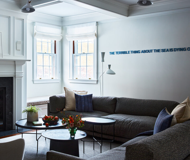 Boston interior decorator designs a modern family room in a historic Concord home, blending contemporary art with traditional architectural details.