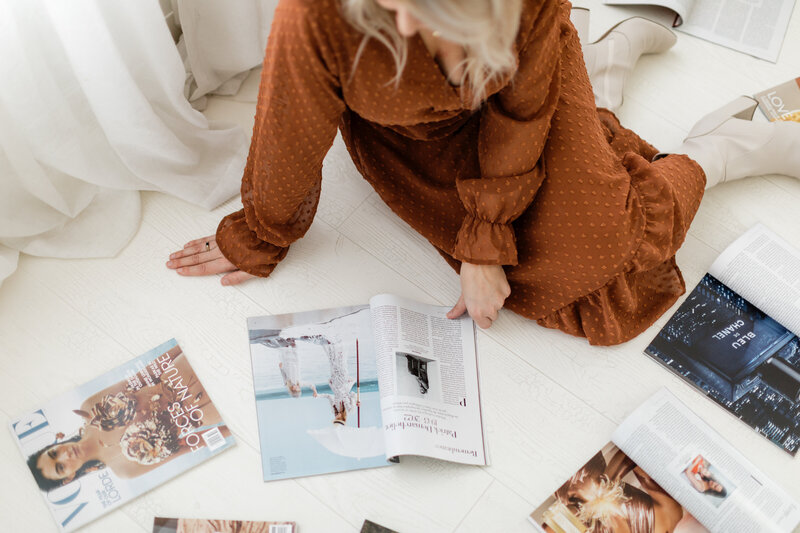 girl sitting on the floor with magazines