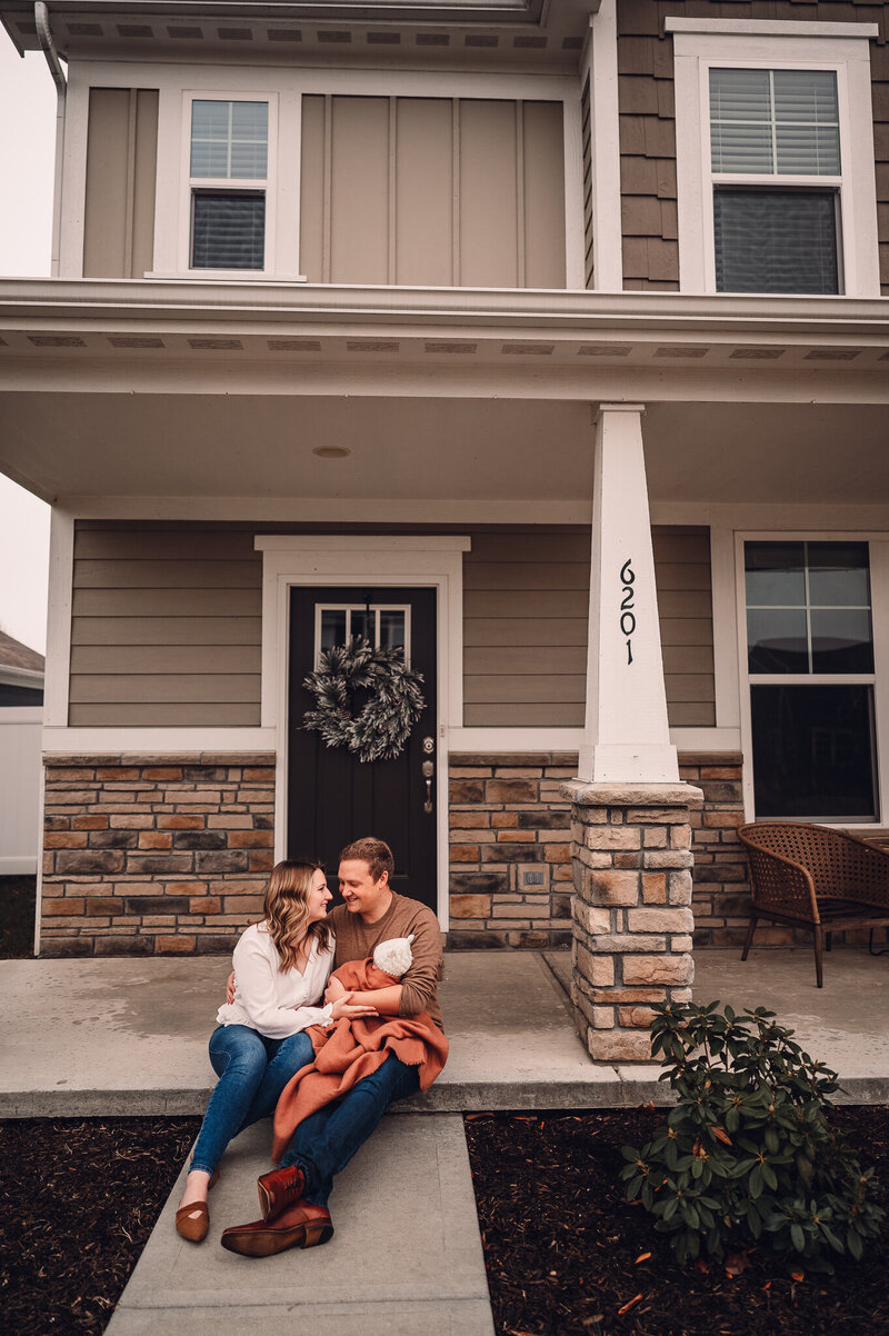 Family holding baby on porch