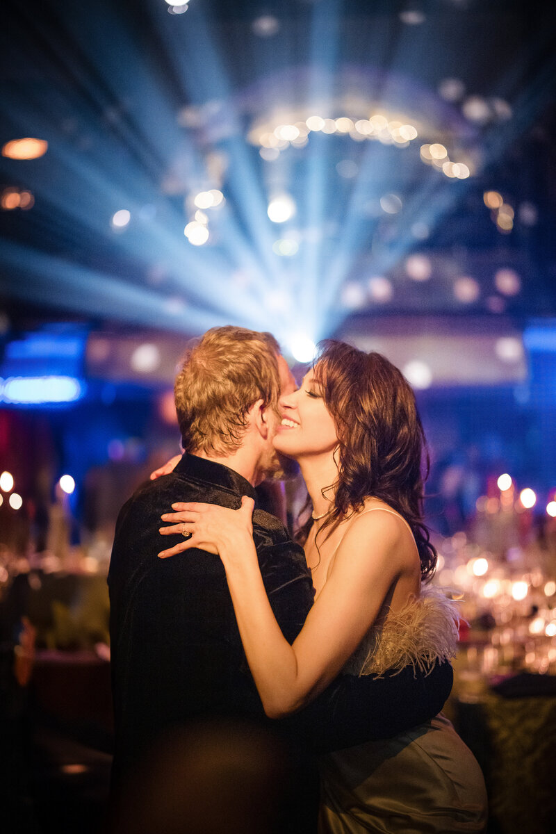 Two women in red beanies about to kiss.