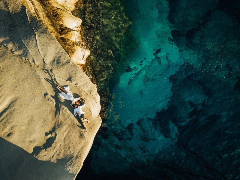 drone photo from above of couple lying on beach