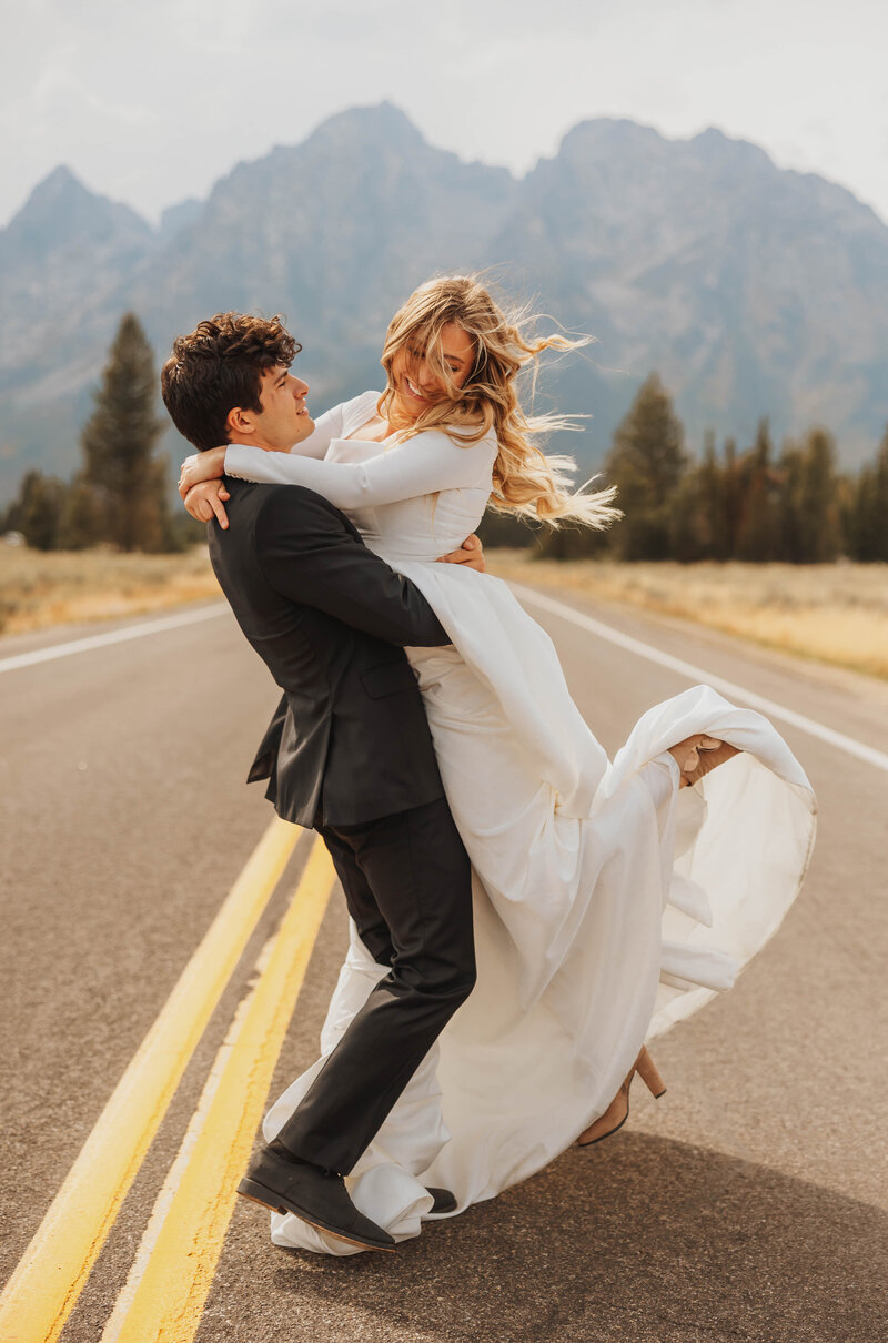 bride and groom posing in road