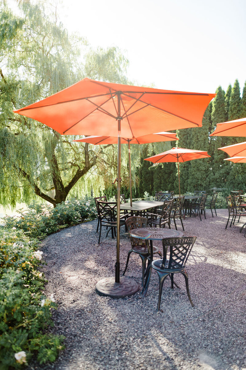Outdoor patio with orange umbrellas and serene greenery