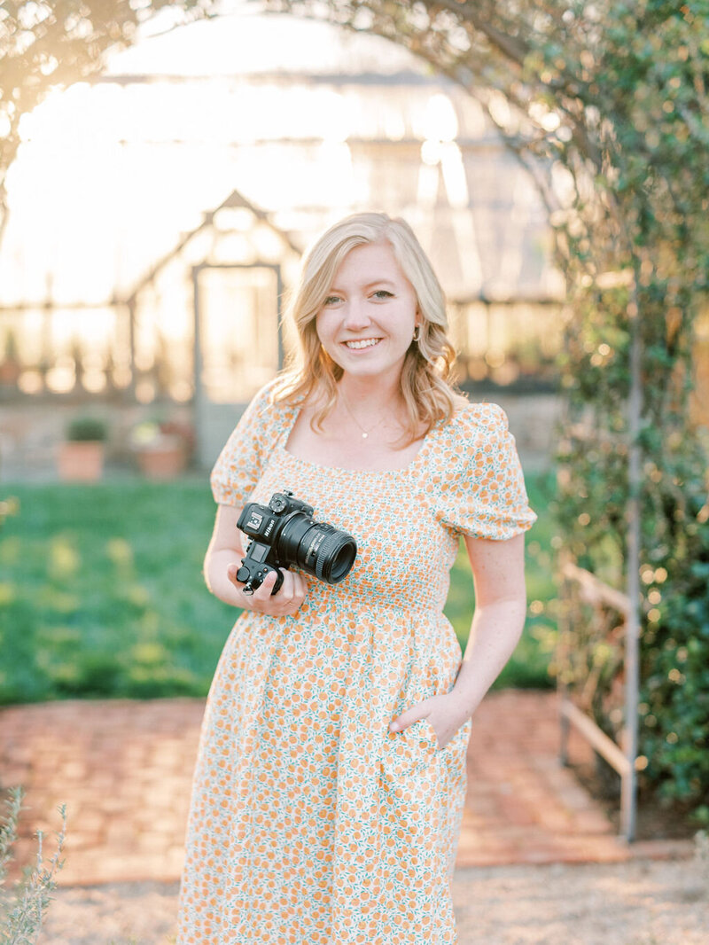 Hadley smiling while holding a camera