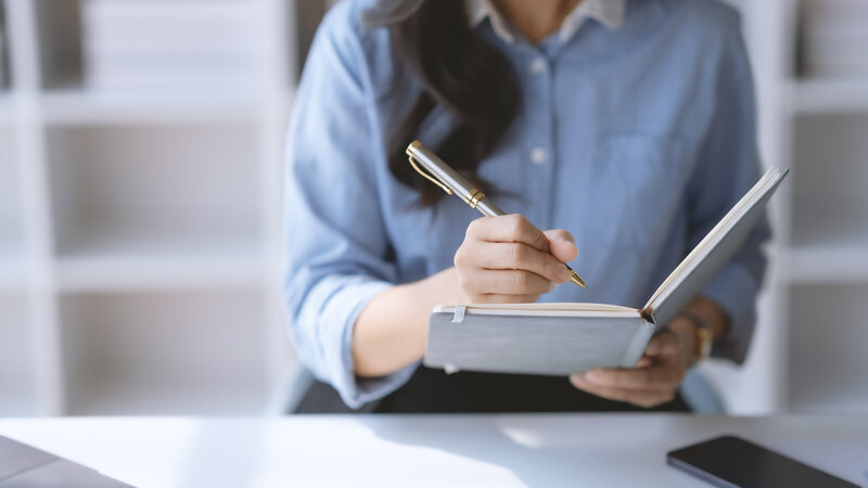 close-up-of-student-woman-hand-writing-on-notebook