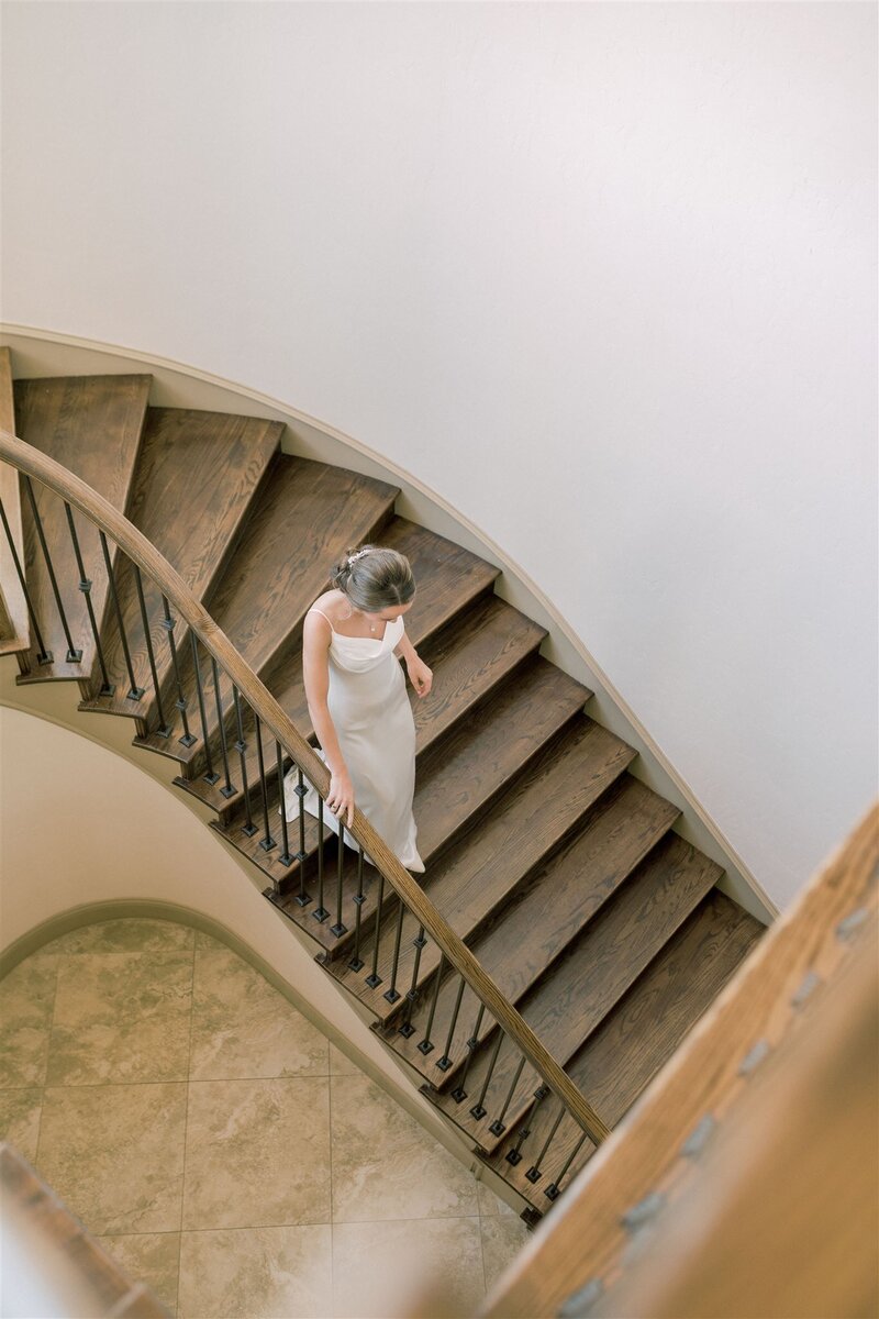bride in gown walking down stairs
