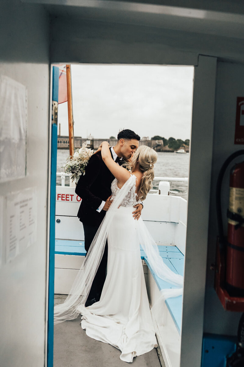bride and groom kissing on boat