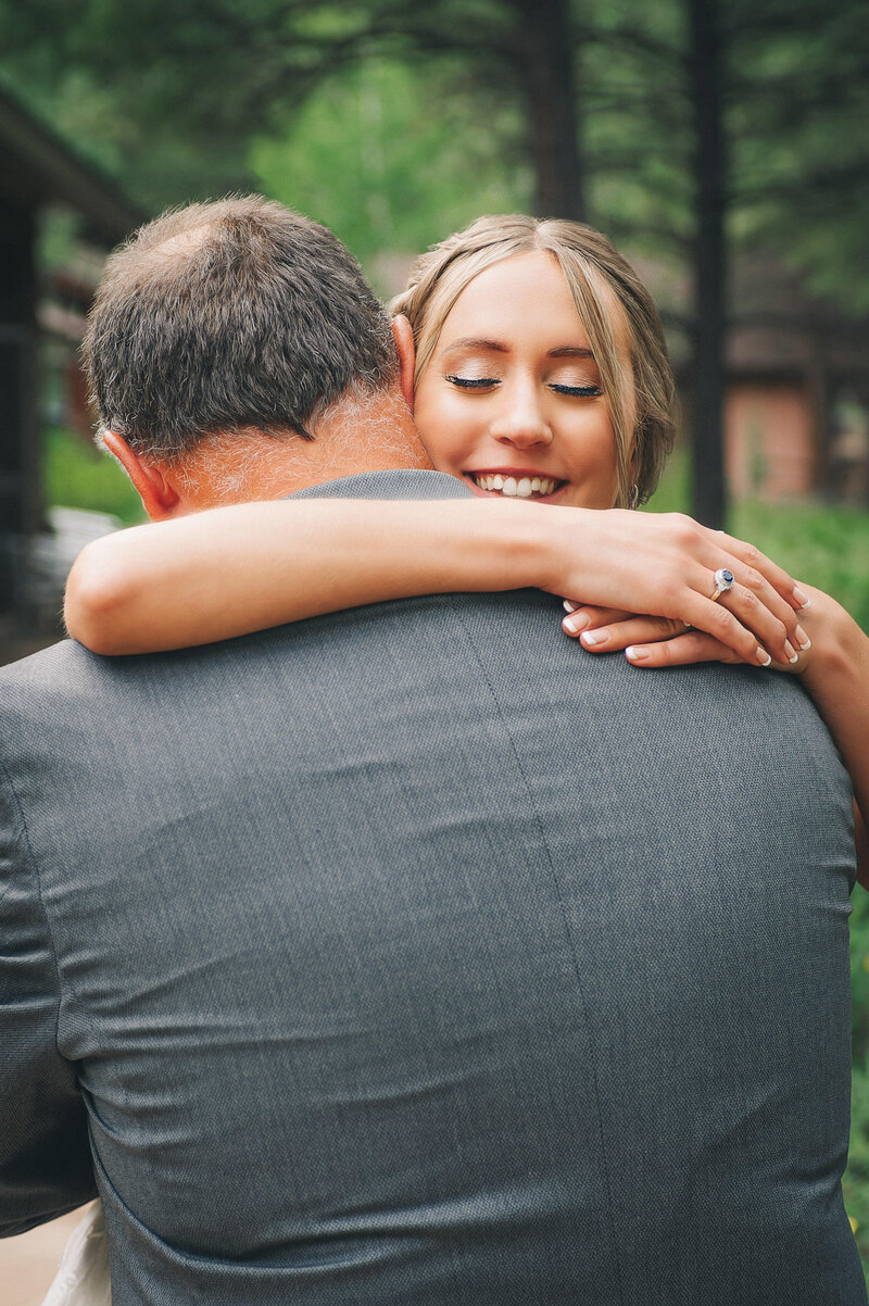 Father of the bride hugs his daughter on her wedding day