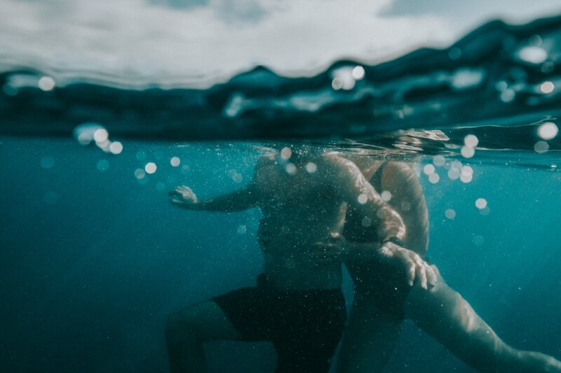 women and man underwater in kauai