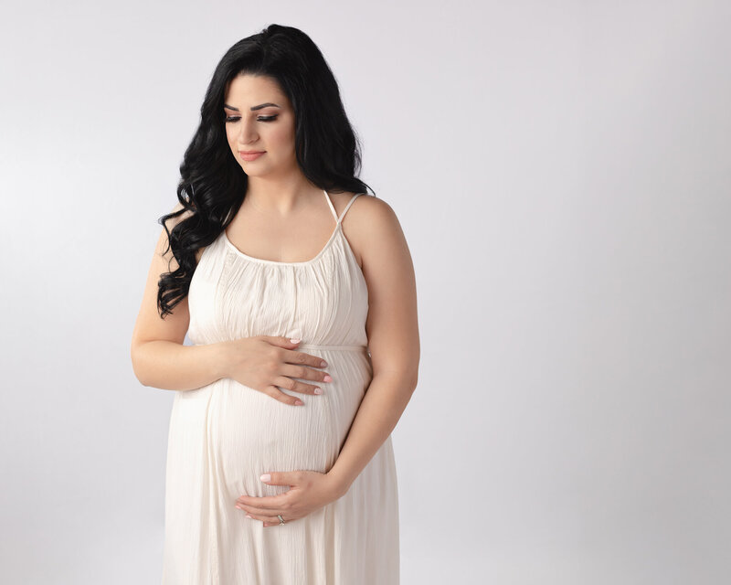 pregnant woman holding belly for studio photoshoot