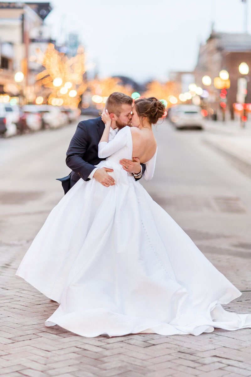 Bride and groom kissing in the street in downtown Fargo ND on their wedding day