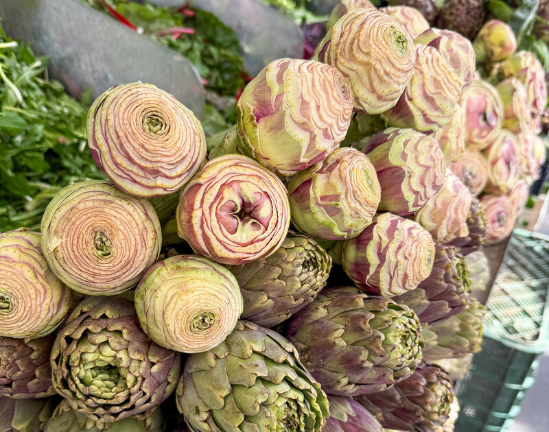 Stacks of fresh artichokes at Testaccio Market in Rome, Italy
