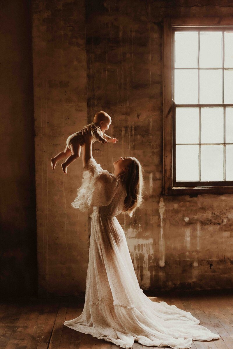 Mother holding baby in rustic Sydney warehouse studio, photographed by Sophie Lea Photography.