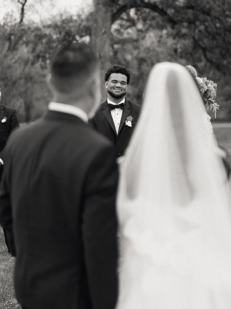 Groom smiling as he sees his bride walking down the aisle.