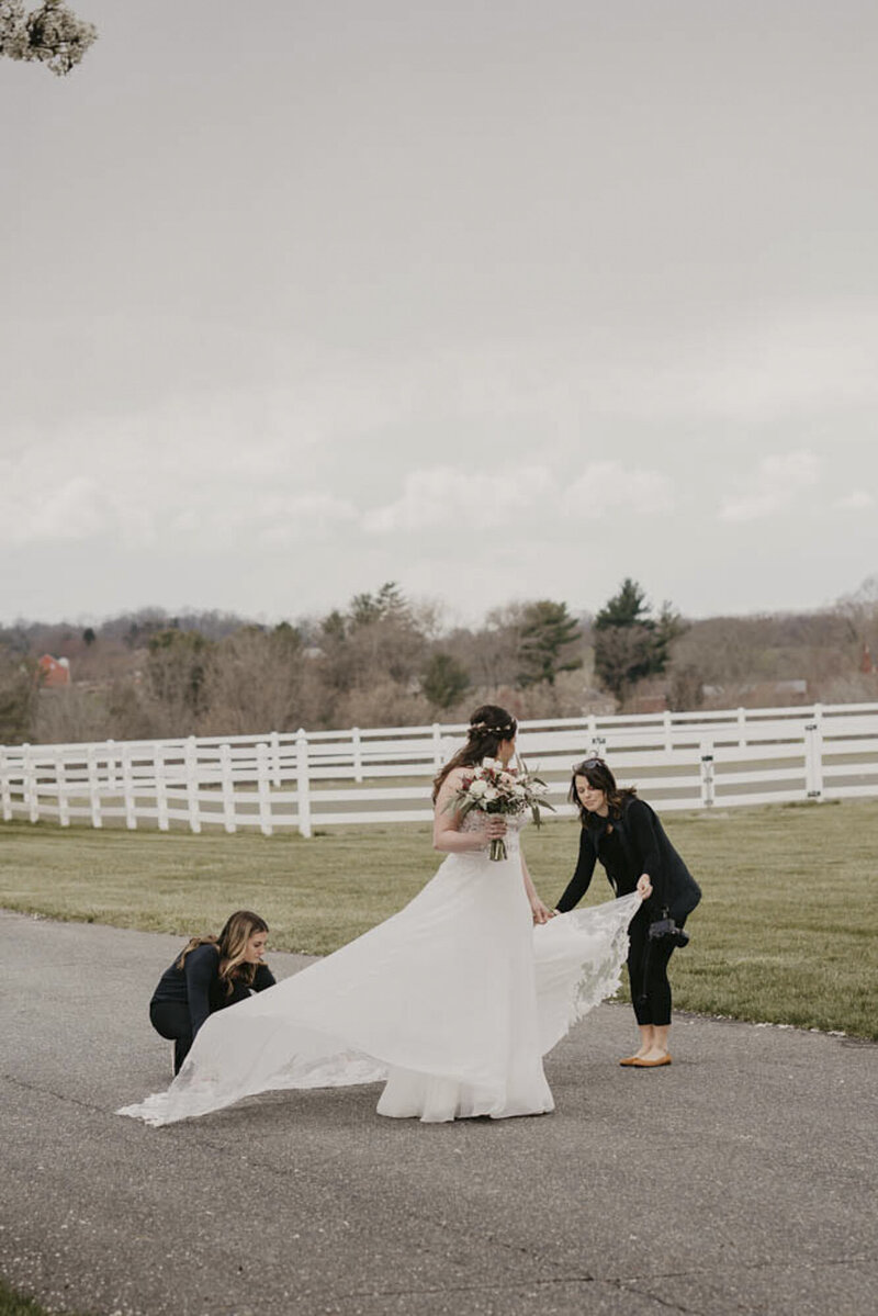 Photographers assisting bride