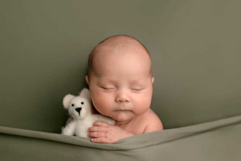 Pace FL Newborn Photographer Baby Holding Teddy Bear Prop in Studio