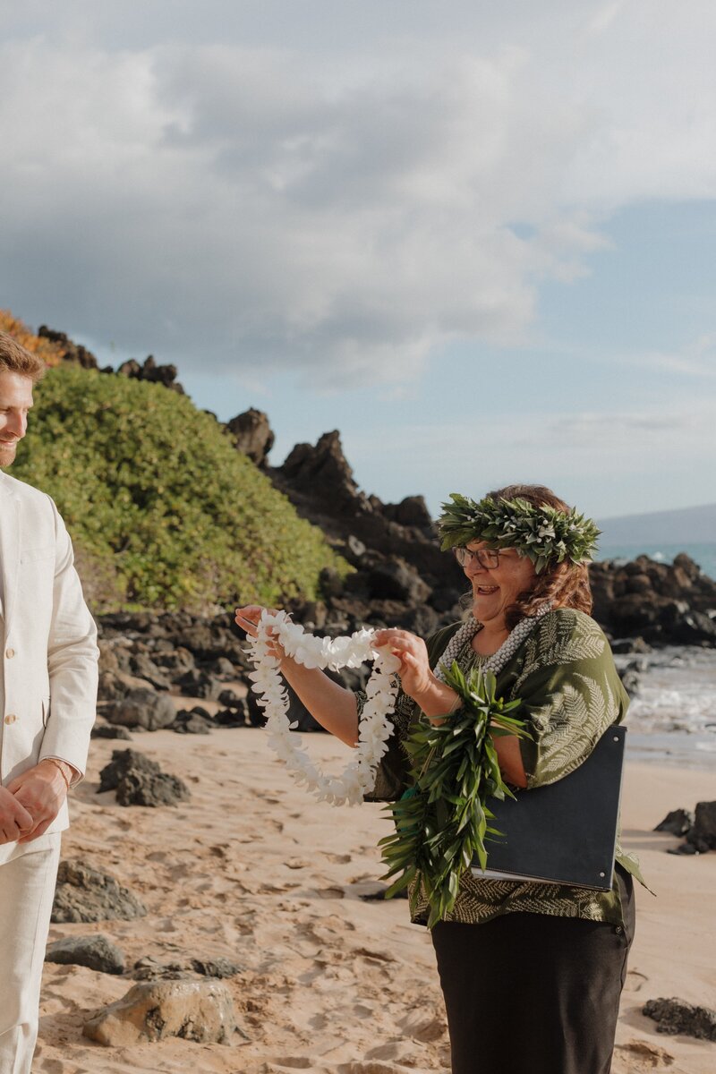marriage officiant holding up a lei in kauai