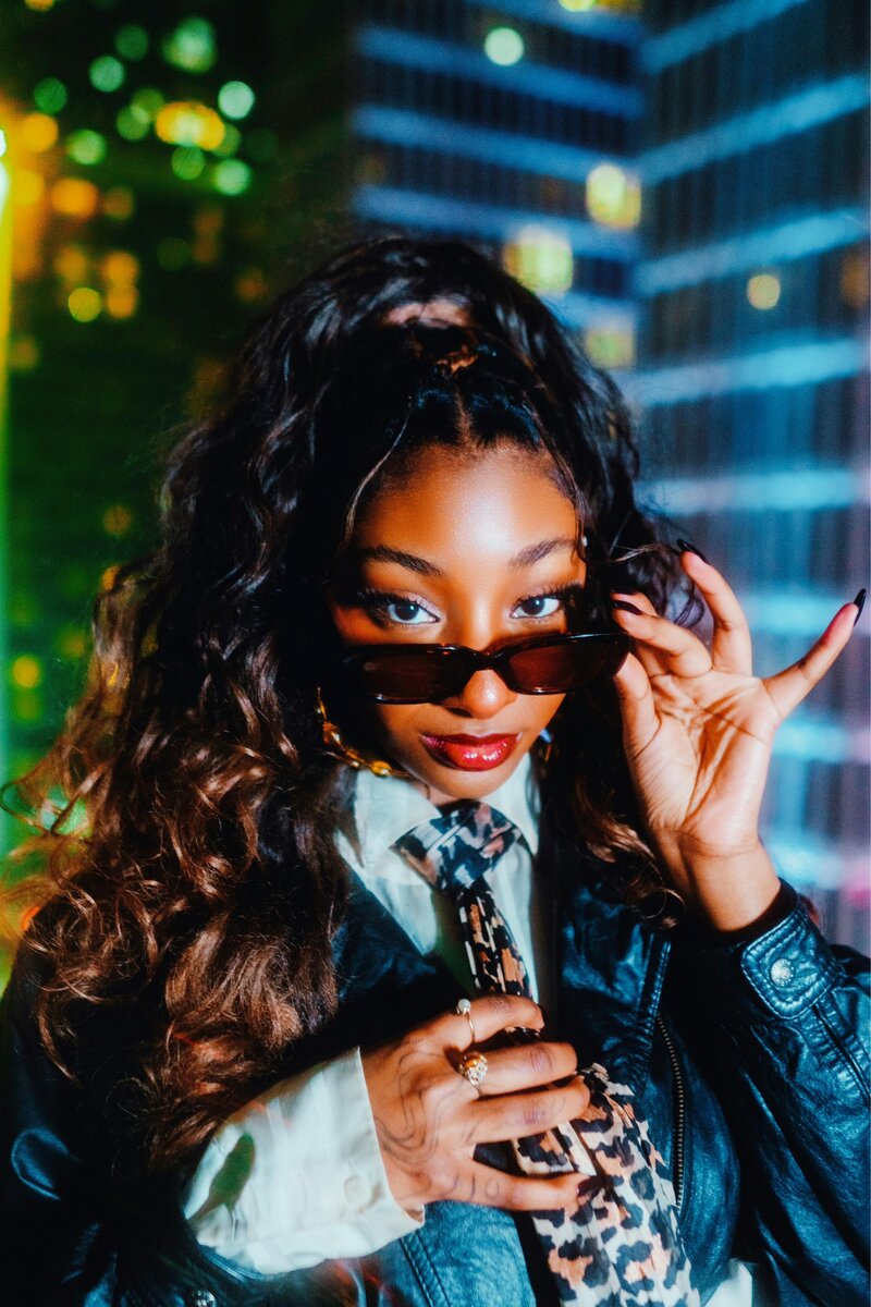 A girl where sunglasses smiles with her unique nail design