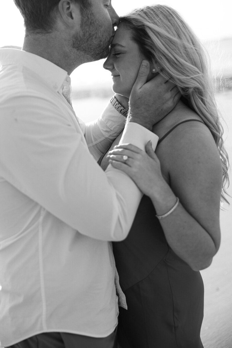a man kissing his fiance on the forehead