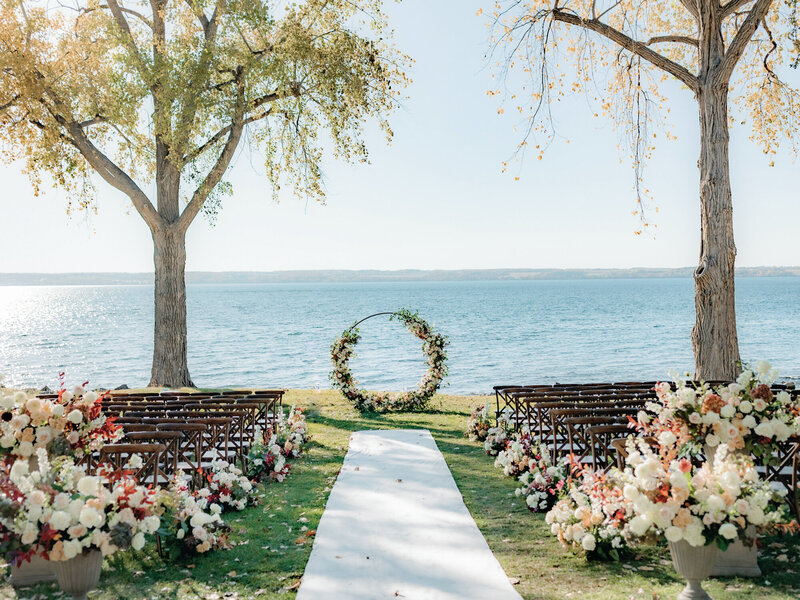 Stunning fall floral aisle with circle altar and lake views at Inns of Aurora.