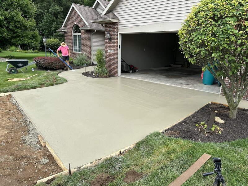 Concrete driveway extension with a curved edge at a brick home in Bristol, IN