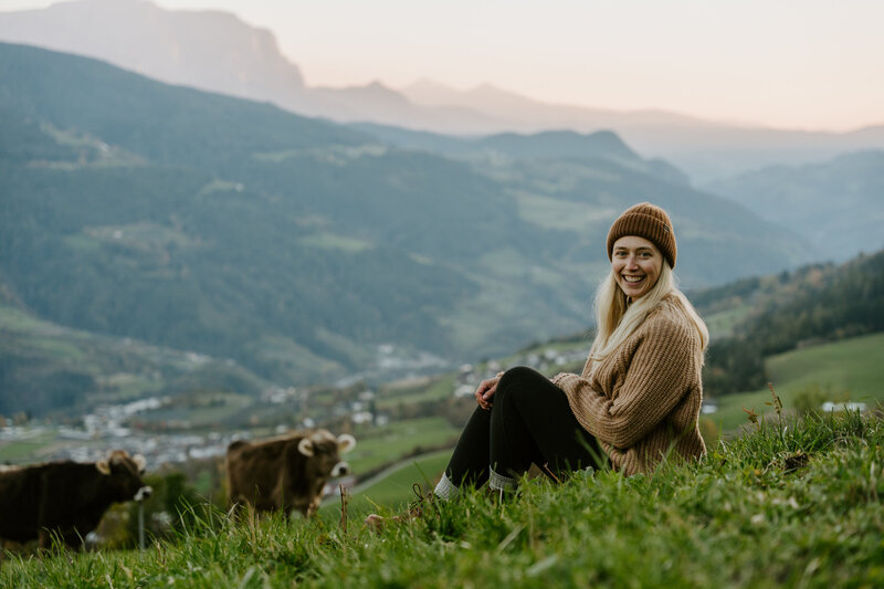 Shawna Rae, Dolomites Elopement Photographer, at sunset with cows