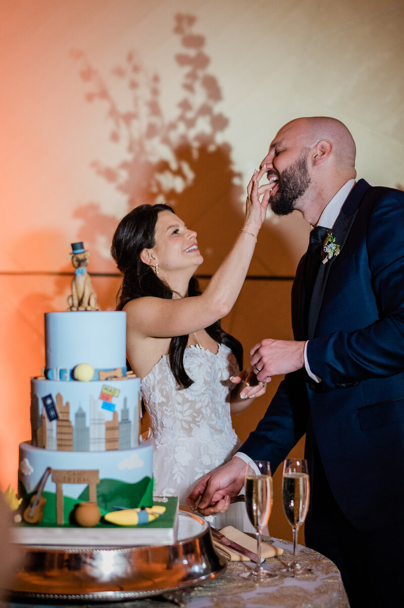 Bride feeds groom cake while groom cuts the cake