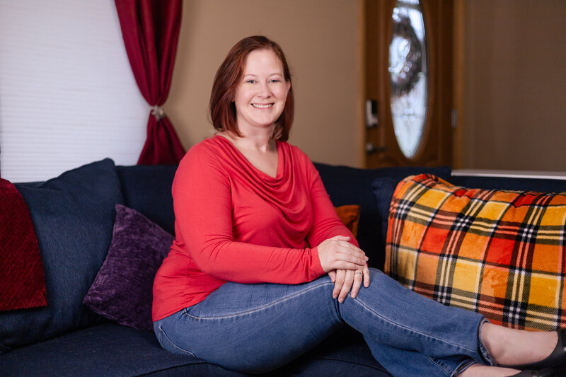 Jean Bishop sitting on the couch smiling at the camera