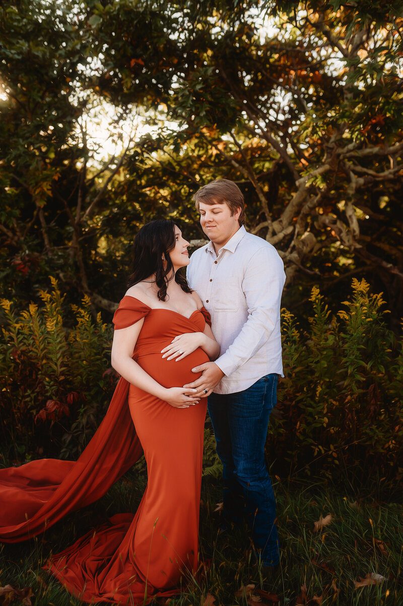 Expectant parents pose for Fall Maternity Photoshoot on the Blue Ridge Parkway in Asheville, NC.