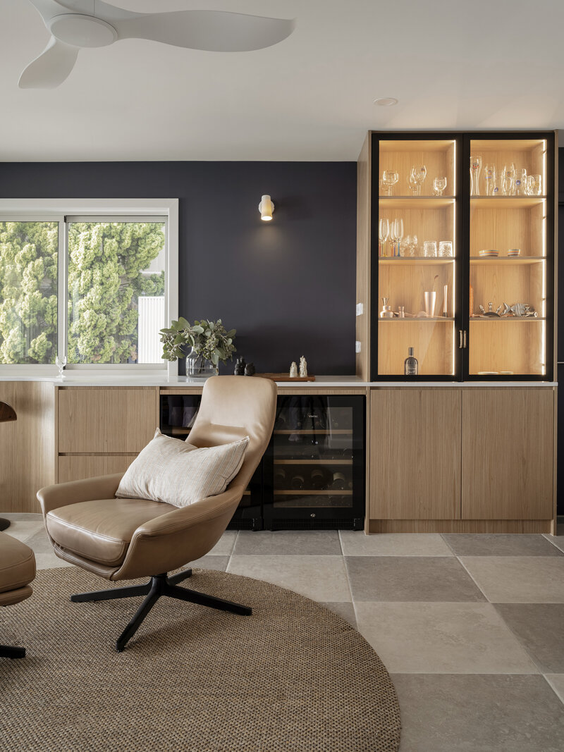 Wooden shelves showcase ceramic bowls, a white pitcher, lemons on a stand, and a glass-covered cheese board—a perfect touch by a Newcastle interior designer.