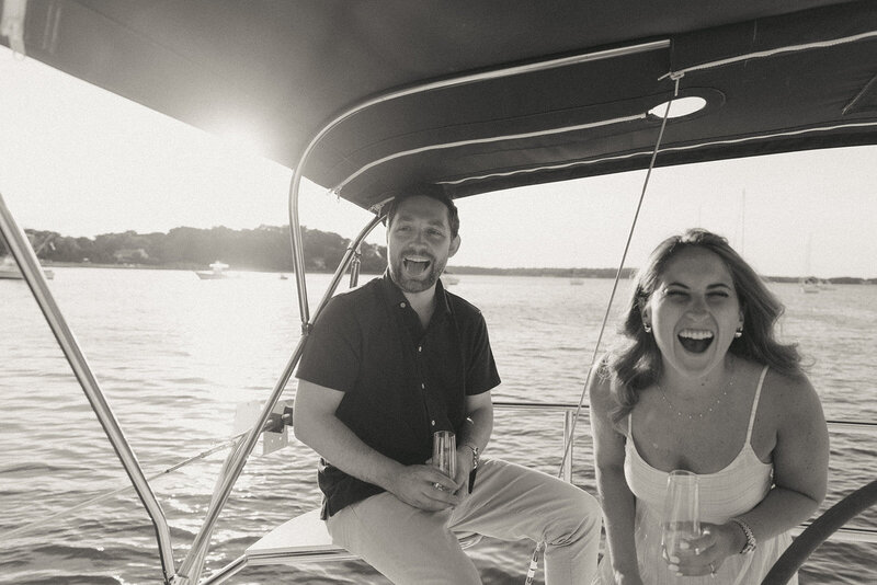 couple laughing on boat during engagement photos, captured by Elsie Goodman, an NYC engagement and couples photographer