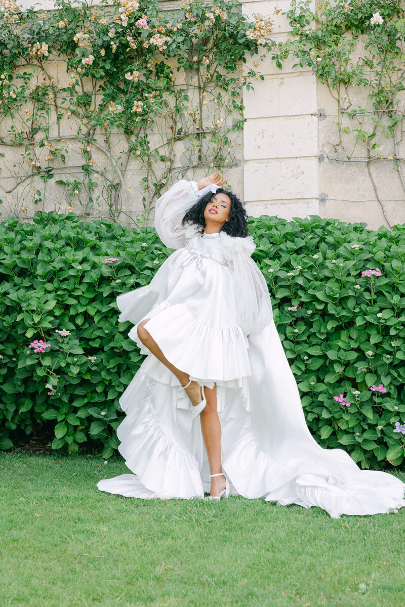 Bride posing for a photo in the gardens of chateau du grand luce during her wedding