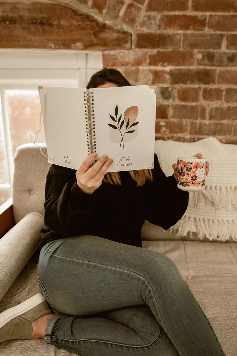 Sam sitting on sheets with flowers and laptop