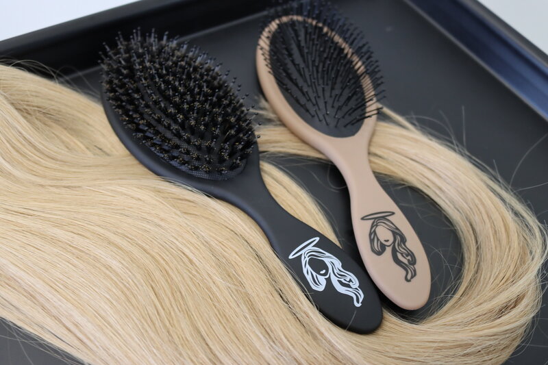 wholy hair extensions and brushes laying on black table