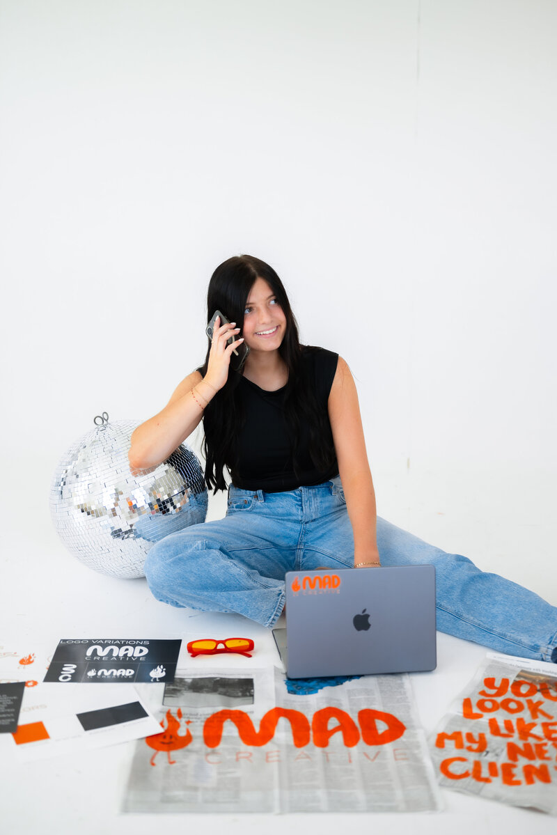 Mad Creative Holding Phone and Working on Computer