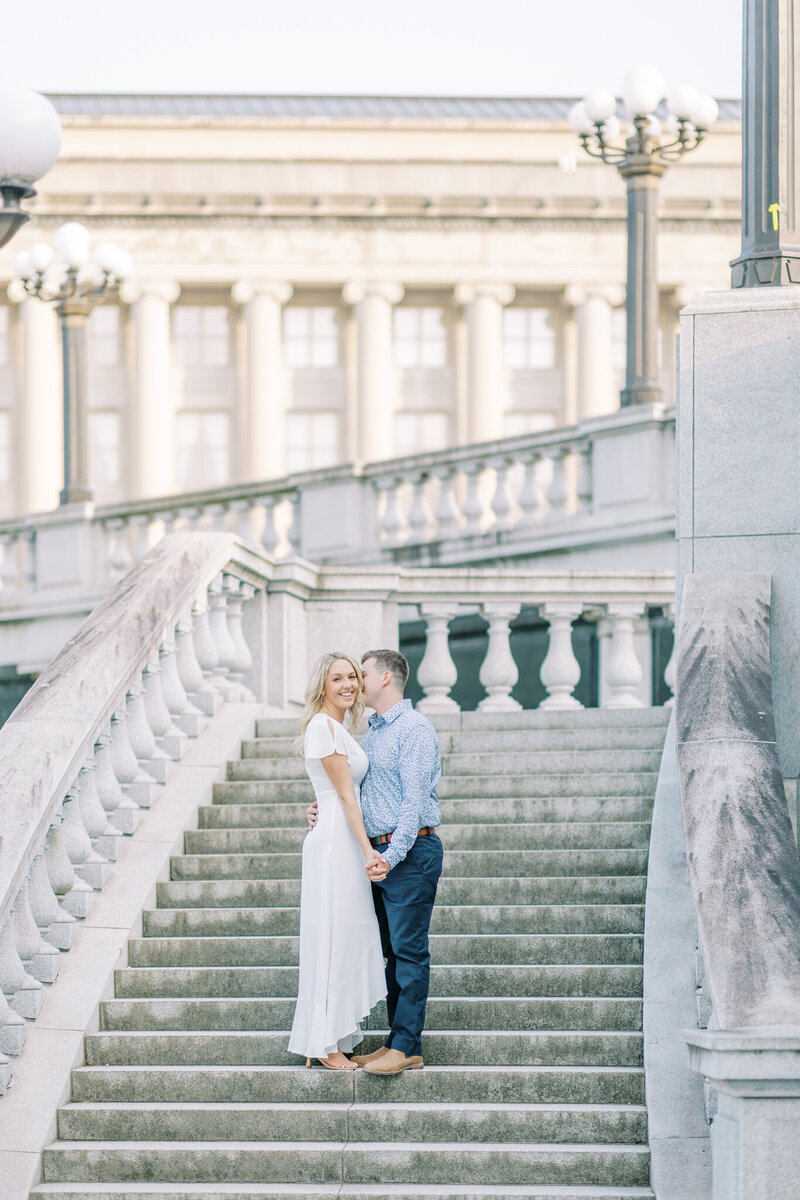 couple stands on the steps of the capitol building to get engaged in PA
