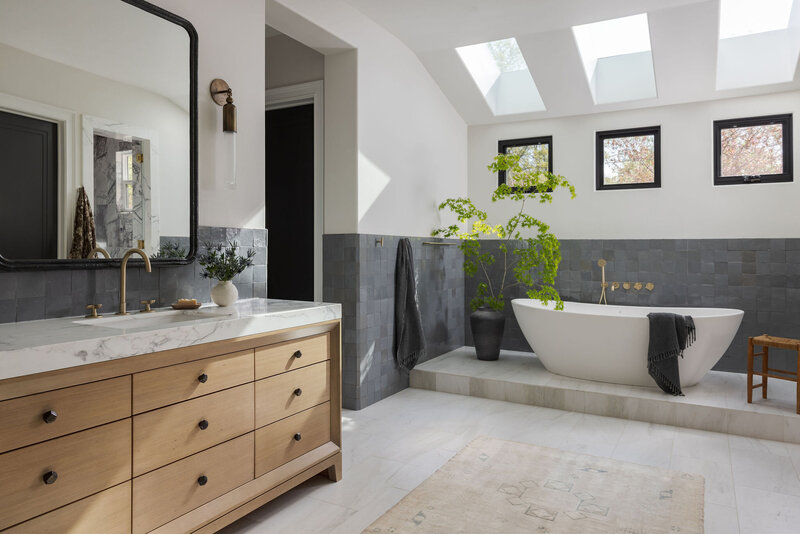 a light-filled primary bathroom remodel created by interior designer haven Studios; marble floors and counters, zellige walls