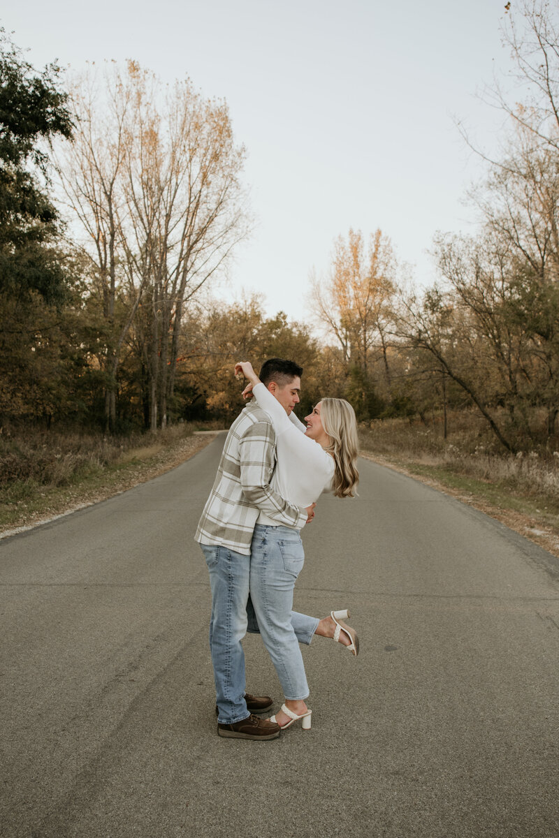 Emotional engagement moment captured in fall trees by luxury Minnesota photographer
